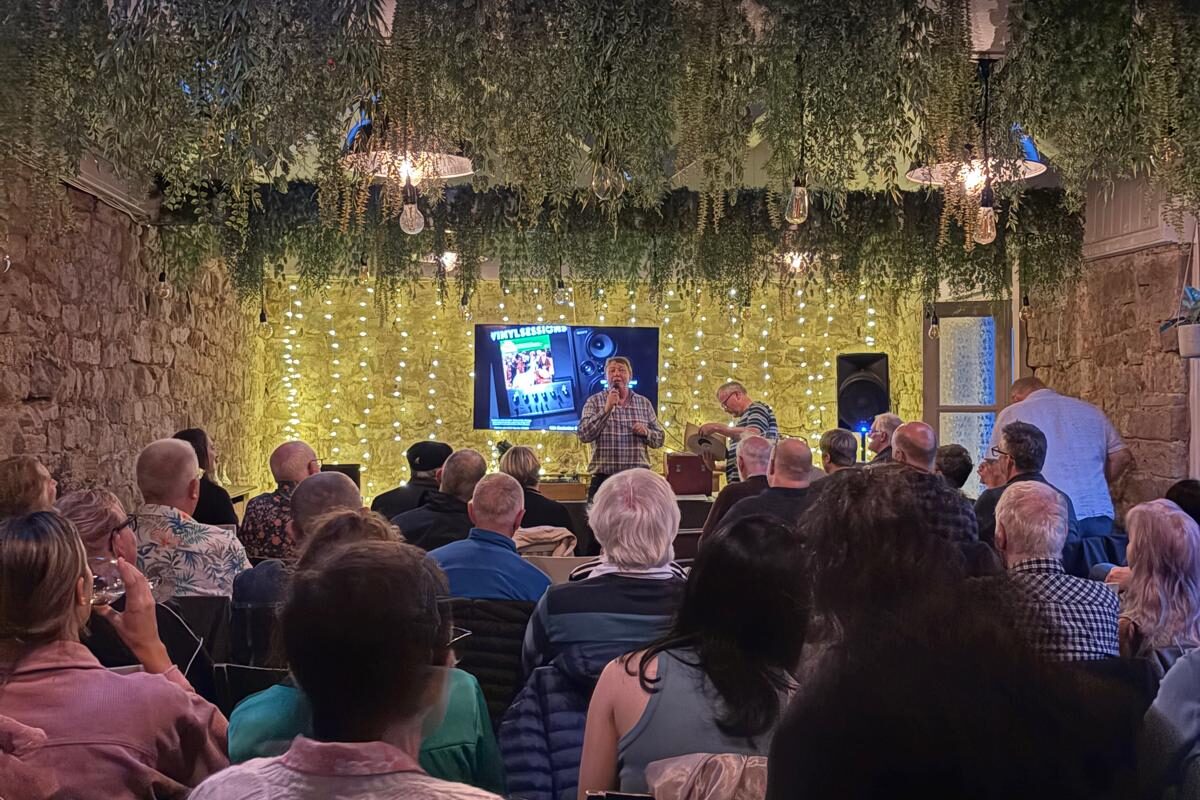 A room is full of people watching a presentation on vinyl records.