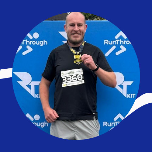 Jake holds a running medal